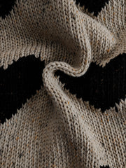 Gilet beige noir à cœurs — gros plan de la maille crème et noire