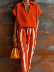 Ensemble maille orange et blanc — gros plan du haut en maille orange et de la ceinture du pantalon rayé