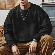Sweat uni à épaules tombantes noir — vue portée assise sur des bûches