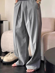 Pantalon ample uni à plis gris — vue portée de face, mains dans les poches