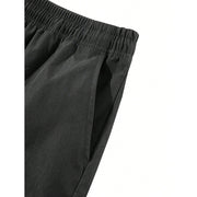 Pantalon cargo poches rabat noir — détail ceinture élastique et poche latérale