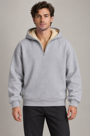 Sweat gris à capuche et zip court porté par un homme, vue de face.