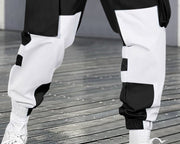 Pantalon cargo contrastes couleurs noir et blanc — gros plan du bas des jambes et des bords-côtes blancs