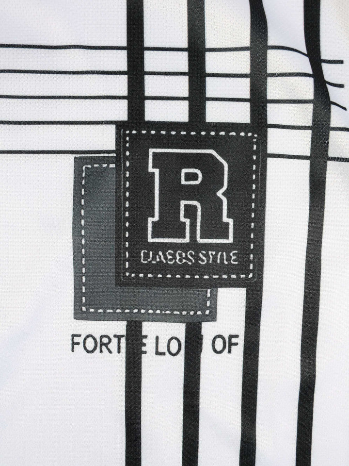 Gros plan d’un t-shirt blanc à motifs noirs avec lettre « R » et texte « CLASSIC STYLE » visible.