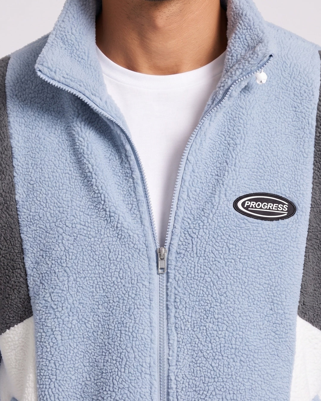 Veste zippée à empiècements contrastés — gros plan du col zippé et de l’écusson