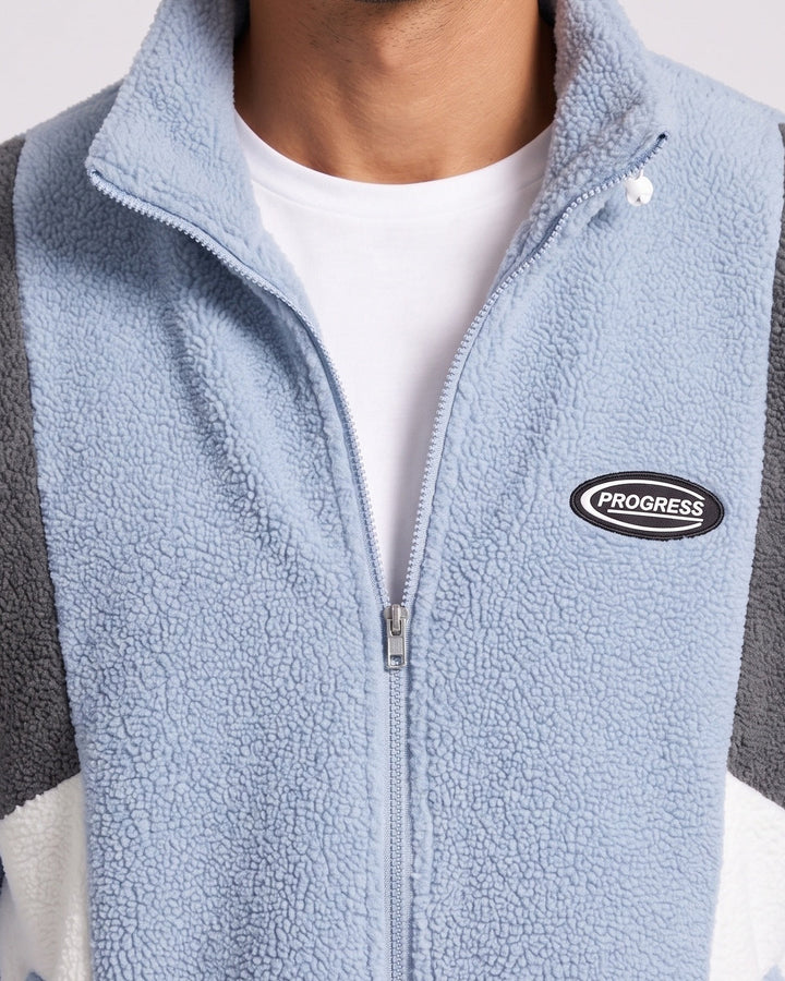 Veste zippée à empiècements contrastés — gros plan du col zippé et de l’écusson