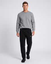 Pantalon jogging cordon poches zippées noir — vue portée de face en studio, avec haut gris