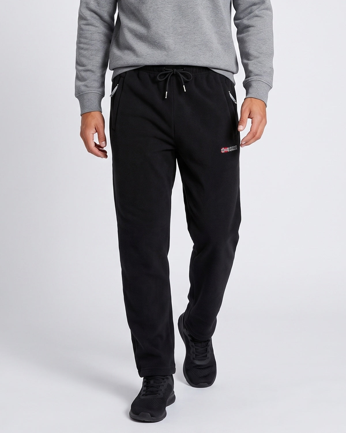Pantalon jogging cordon poches zippées noir — vue portée de face, avec sweat gris