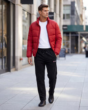Pantalon jogging cordon poches zippées noir — vue portée en ville, avec doudoune rouge