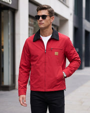 Veste courte zippée rouge à col noir, vue portée en extérieur avec lunettes