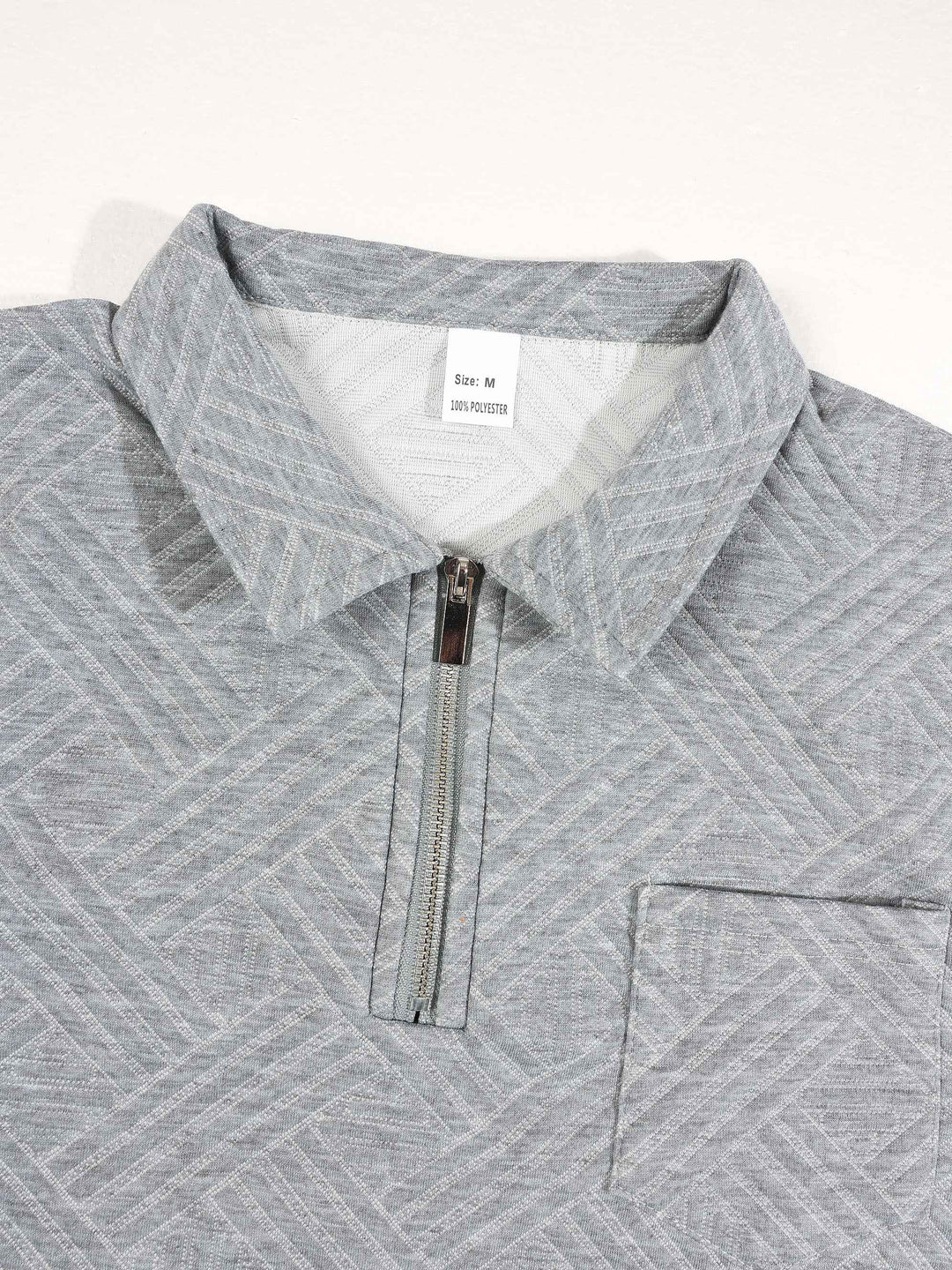 Tenue polo et pantalon gris, détail du col zippé