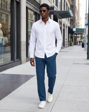 Pantalon légèrement évasé bleu marine — vue portée en marche, avec chemise blanche