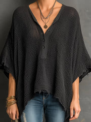 Pull ample à manches chauve-souris noir — gros plan de l'encolure et des bijoux