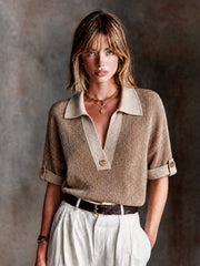 Haut beige camel col polo — vue portée en pied, devant un mur texturé