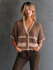 Gilet camel à bordures contrastées — vue portée en pied, devant un mur en béton gris