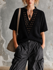 Haut noir col montant V — vue portée de face, col en V profond, pantalon cargo sombre et colliers