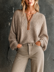 Pull beige à demi-zip contrastant — vue portée de face, long pompon décoratif au col en V, maille chinée