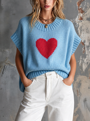 Pull bleu clair cœur rouge — vue portée de face, mains dans les poches