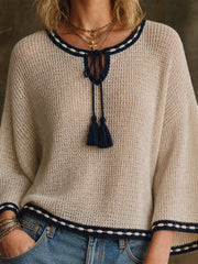 Pull crème marine à cordons — gros plan de l'encolure fendue, des cordons à pompons et de la broderie