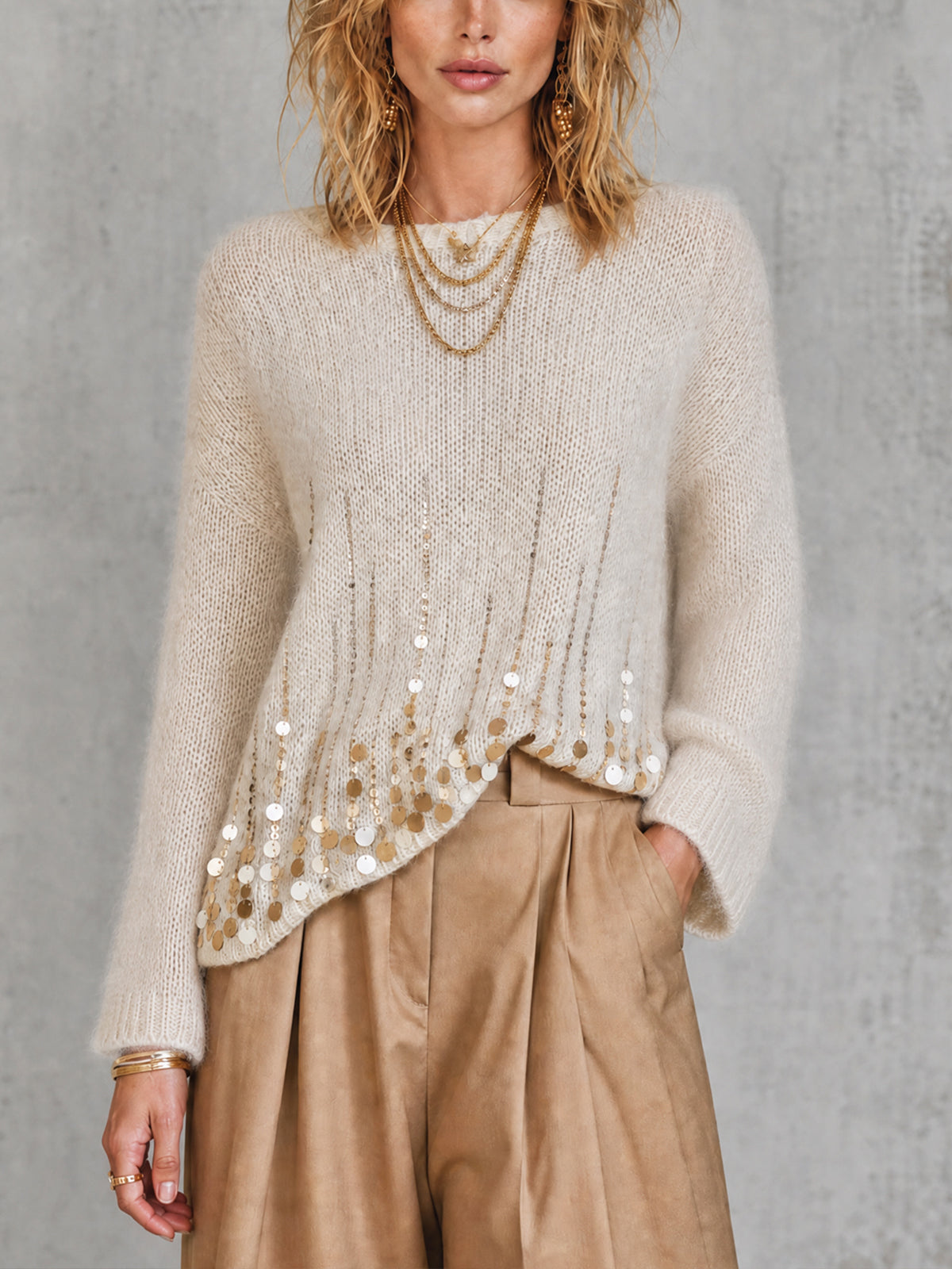 Pull crème à sequins — vue portée de face, pantalon large beige et colliers dorés