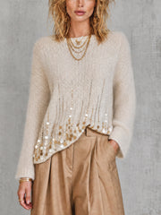 Pull crème à sequins — vue portée de face, pantalon large beige et colliers dorés
