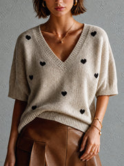 Pull avoine à motif cœurs — vue rapprochée de face, petits cœurs noirs, jupe en similicuir marron