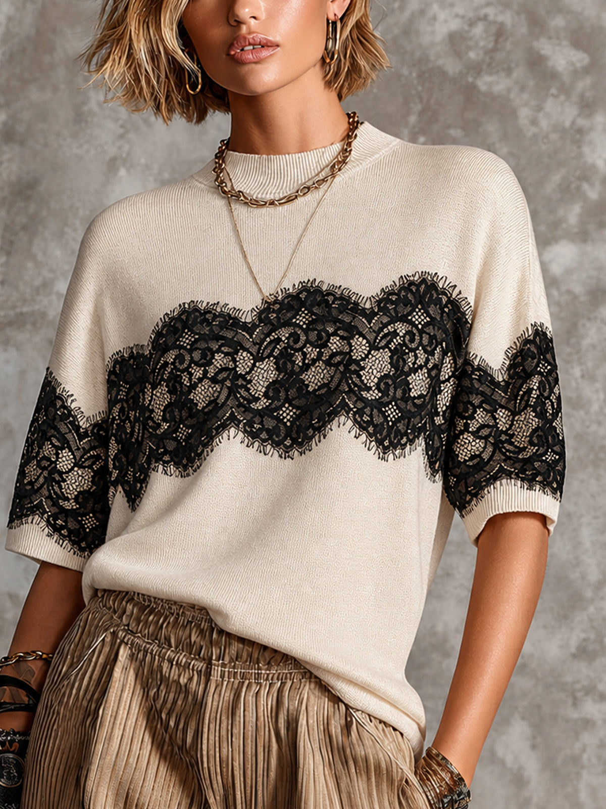 Pull crème noir col montant — vue rapprochée de face, bande de dentelle florale noire sur la poitrine