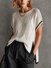 Pull blanc-noir ajouré col rond — vue portée de face, liseré noir sur les côtés et les manches, pantalon sombre