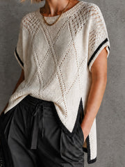 Pull blanc-noir ajouré col rond — gros plan du liseré noir à l'emmanchure et du motif en relief