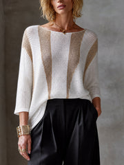 Pull blanc col bateau — vue portée de face, larges rayures verticales dorées, pantalon noir