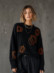 Pull noir à citrouille brodée — vue portée en pied, pantalon large noir