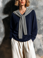 Pull marine gris effet foulard — vue portée de face, pull gris clair noué sur les épaules, pantalon blanc cassé