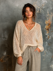 Pull écru à capuche — vue portée en pied, pantalon large taupe