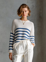 Pull crème marine à rayures — vue portée en pied, devant un mur en béton gris