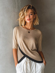 Pull beige bas croisé contrastant — vue portée de face, autre posture, pantalon blanc