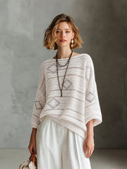 Pull blanc-gris losanges col bateau — vue portée en pied, pantalon blanc large et petit sac
