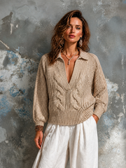 Pull beige à torsades — vue portée de face, devant un mur marbré gris