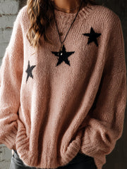 Pull rose à motifs étoiles — vue portée de trois-quarts, détail des étoiles noires et de la maille