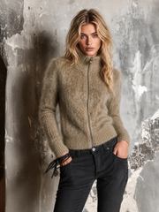 Cardigan taupe clair zippé porté avec un pantalon noir.