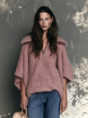 Pull rose col revers zippé — vue portée de trois-quarts, regard par-dessus l'épaule