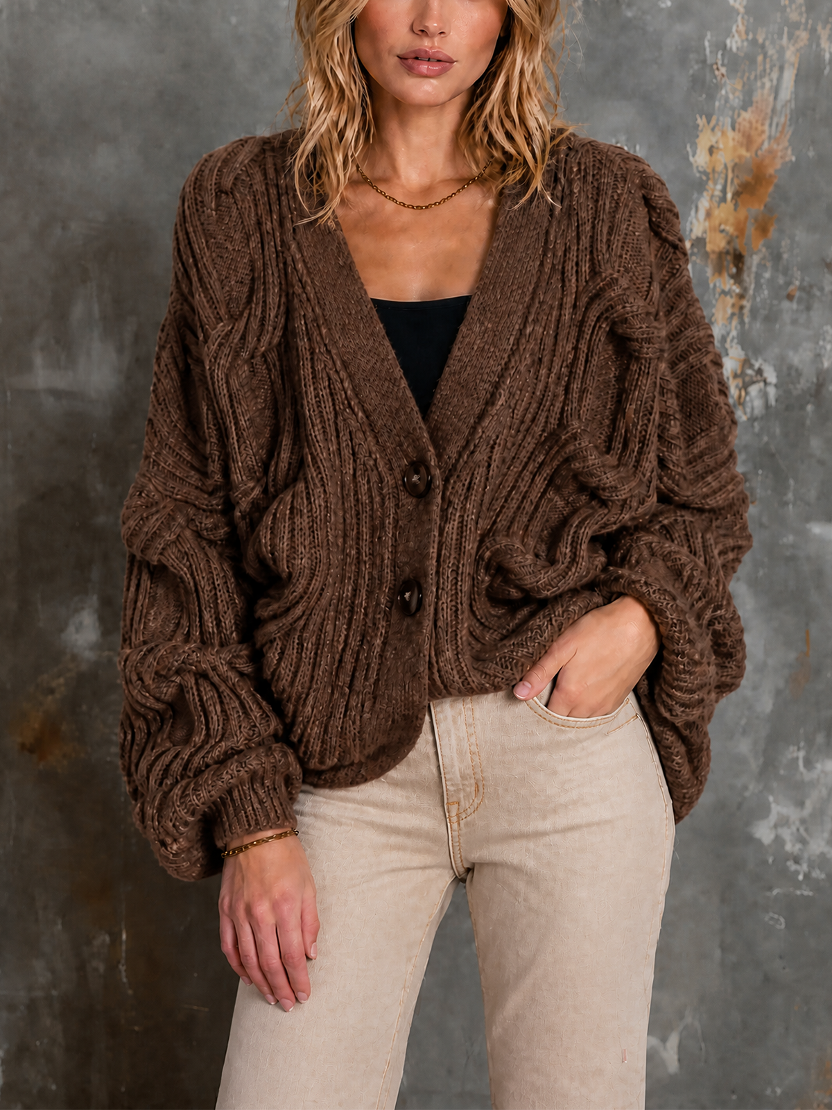 Cardigan brun à torsades — vue portée de face, cadrée à la taille, mains le long du corps