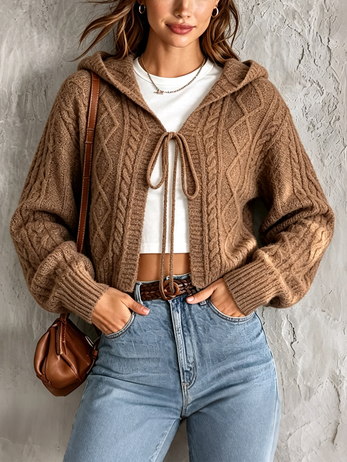 Cardigan court brun à capuche — vue portée de face, lien noué sur le haut blanc, jean et ceinture marron