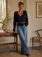 Pull bleu marine torsadé ceinturé — vue portée en pied, en intérieur près d'un bureau en bois