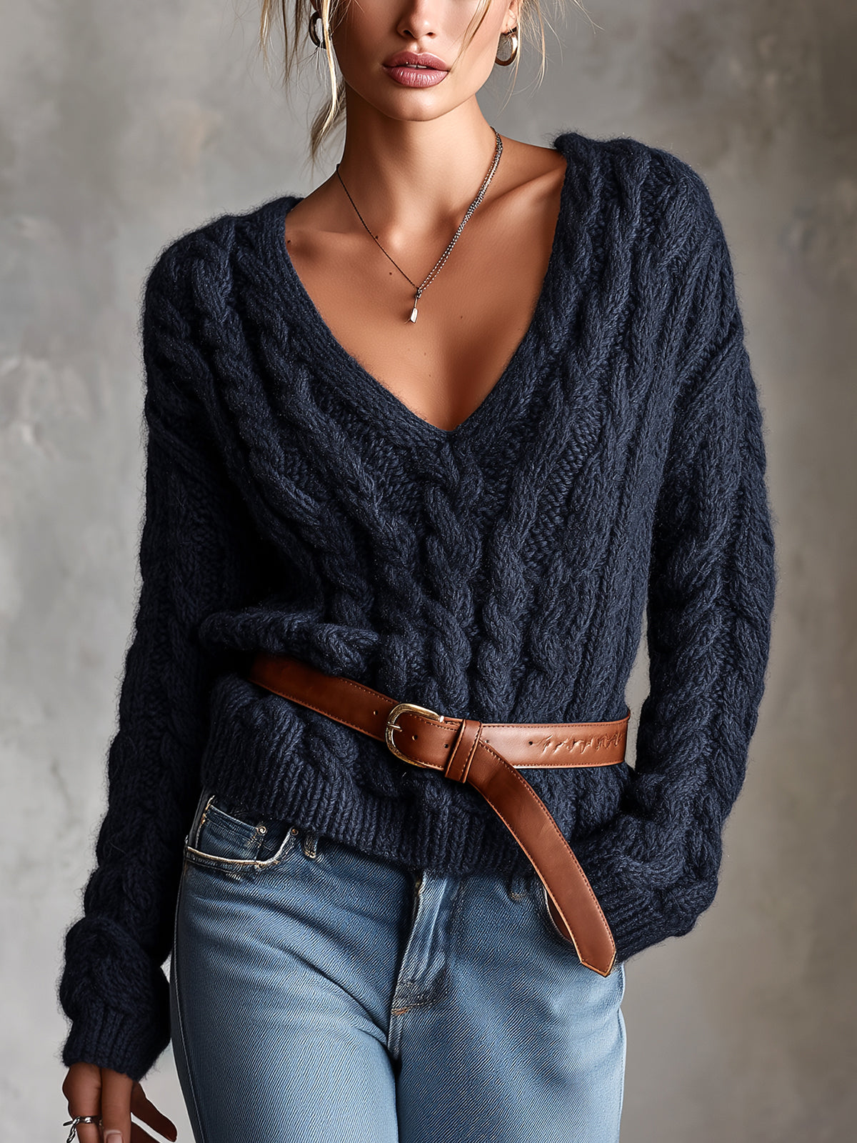 Pull bleu marine torsadé ceinturé — vue portée de face, cadrée à la taille, torsades épaisses