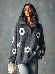 Pull gris boutonné à fleurs — vue portée de trois-quarts, devant un mur gris