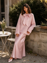 Ensemble rose pull noué — vue portée assise à une table de café fleurie