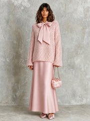 Ensemble rose pull noué — vue portée de trois-quarts, devant un fond gris neutre