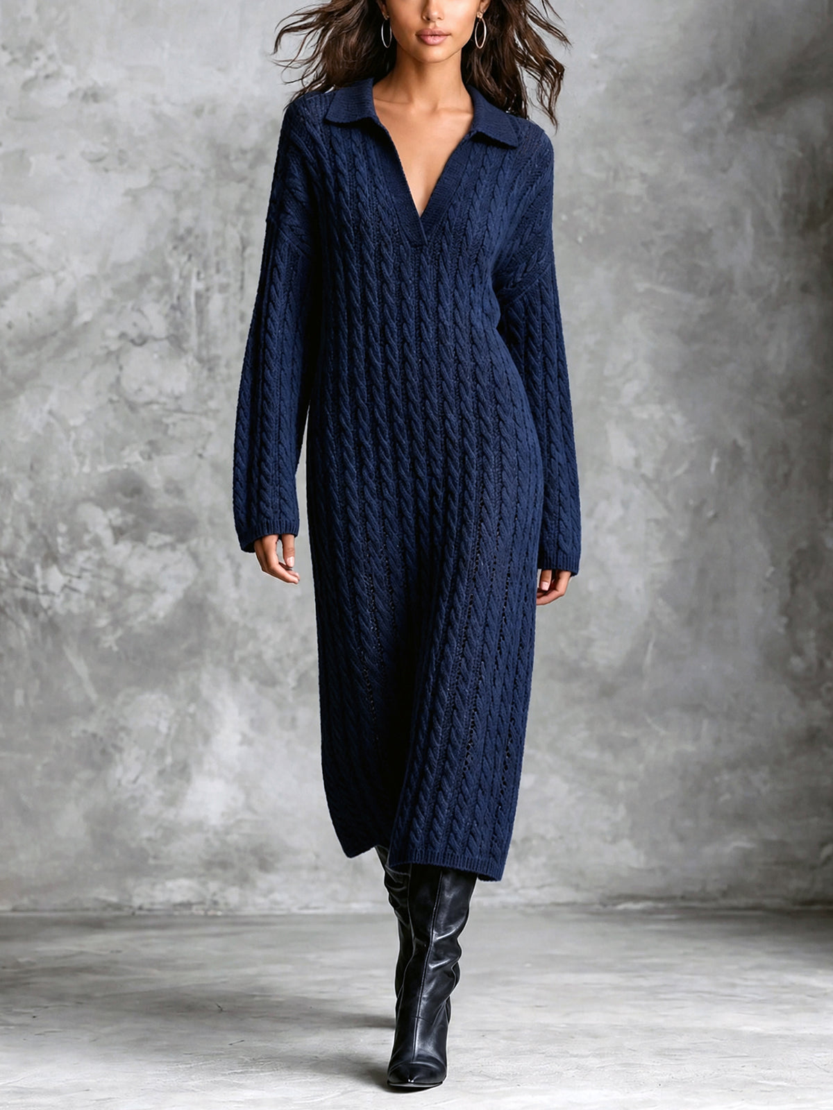 Robe midi marine à torsades — vue portée en pied, hautes bottes noires, devant un mur gris texturé