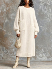 Robe longue crème poche plaquée — vue portée en pied, bottines claires et petit sac perlé, regard baissé