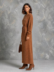 Robe longue caramel col V — vue portée de trois-quarts, regard par-dessus l'épaule